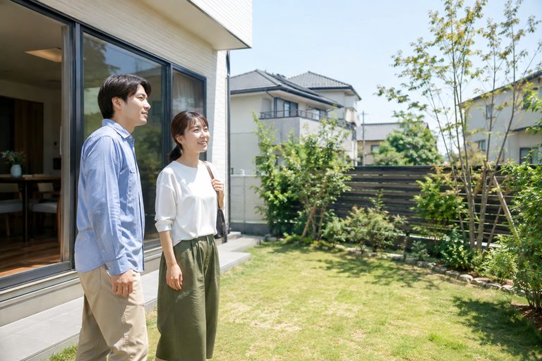 庭付きの一戸建てを夫婦で見学している様子