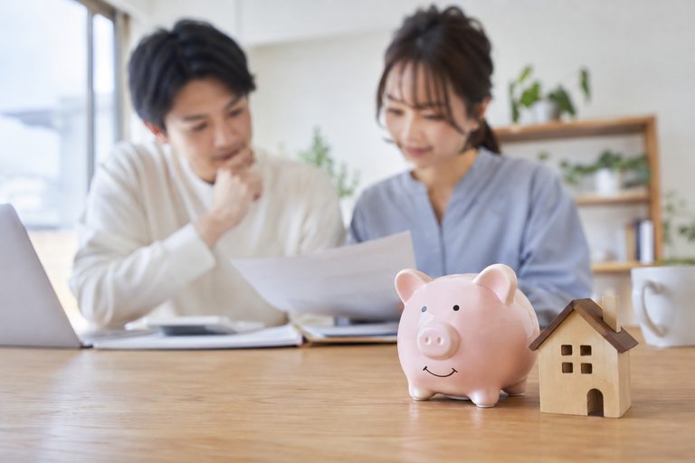 貯金箱と小さな木製の住宅模型が並んでいる様子